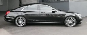 A side profile view of a polished black Mercedes-Benz S-Class luxury sedan.